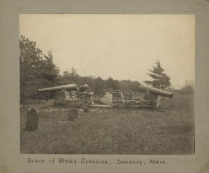 View of grave of Myles Standish with stone wall and cannons, tombstones in foreground.