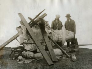 Men standing next to a bust sculpture of Myles Standish with support structure nearby